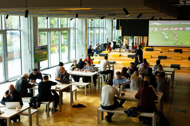 large open events space with tables, bleacher seating and large screen