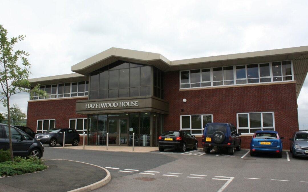 brown brick two storey office building with glass facade over entrance and hazelwood house signage